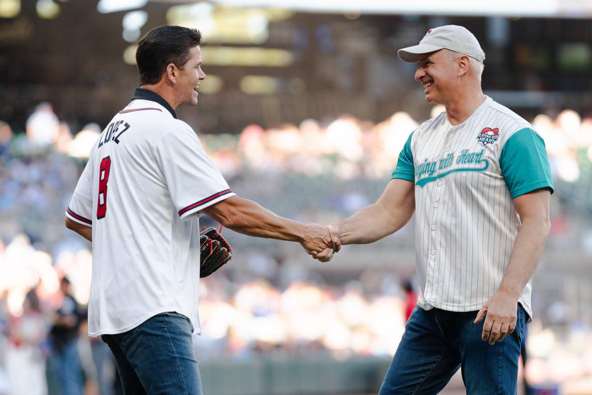 two men wearing baseball jerseys shaking hands