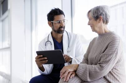older woman sitting and talking with doctor