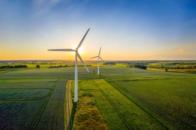 Wind turbines in a green field with a blue sky