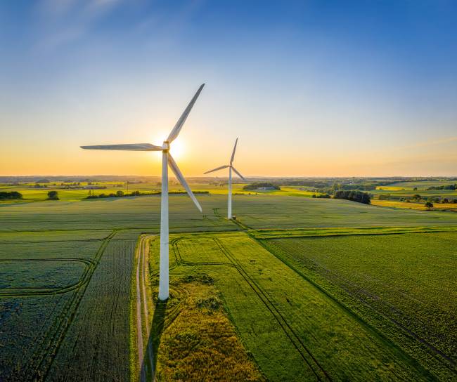 Wind turbines in a green field with a blue sky