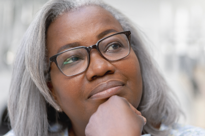 Woman leaning on her hand, looking up in and thinking