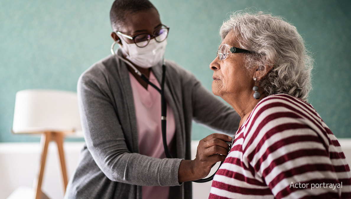 Doctor with stethoscope listens to patient