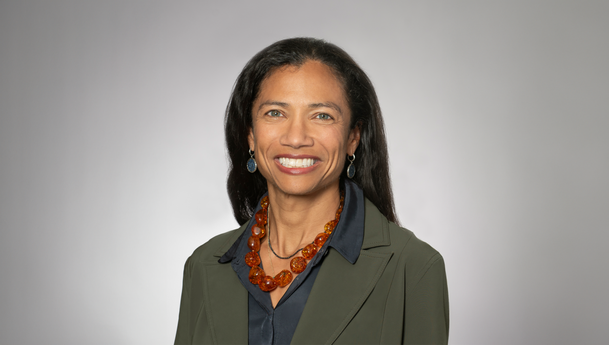 portrait of a women wearing neckless and earrings in green blazer