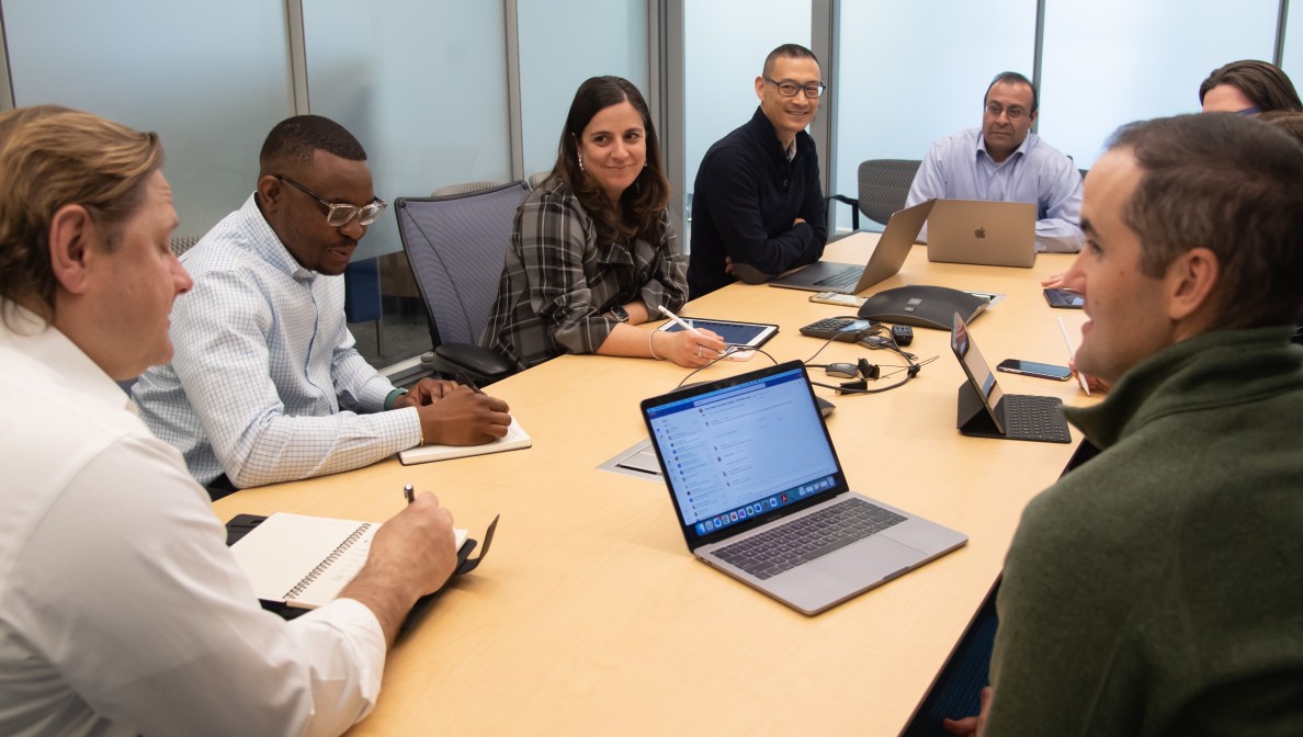 Men and women sitting around conference room table talking