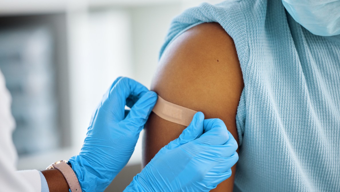 healthcare working putting a bandaid on a child's arm