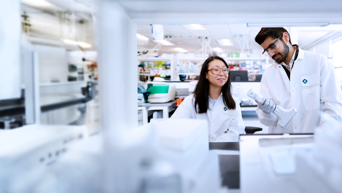 two scientists wearing lab coats working in a lab