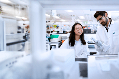 two scientists wearing lab coats working in a lab