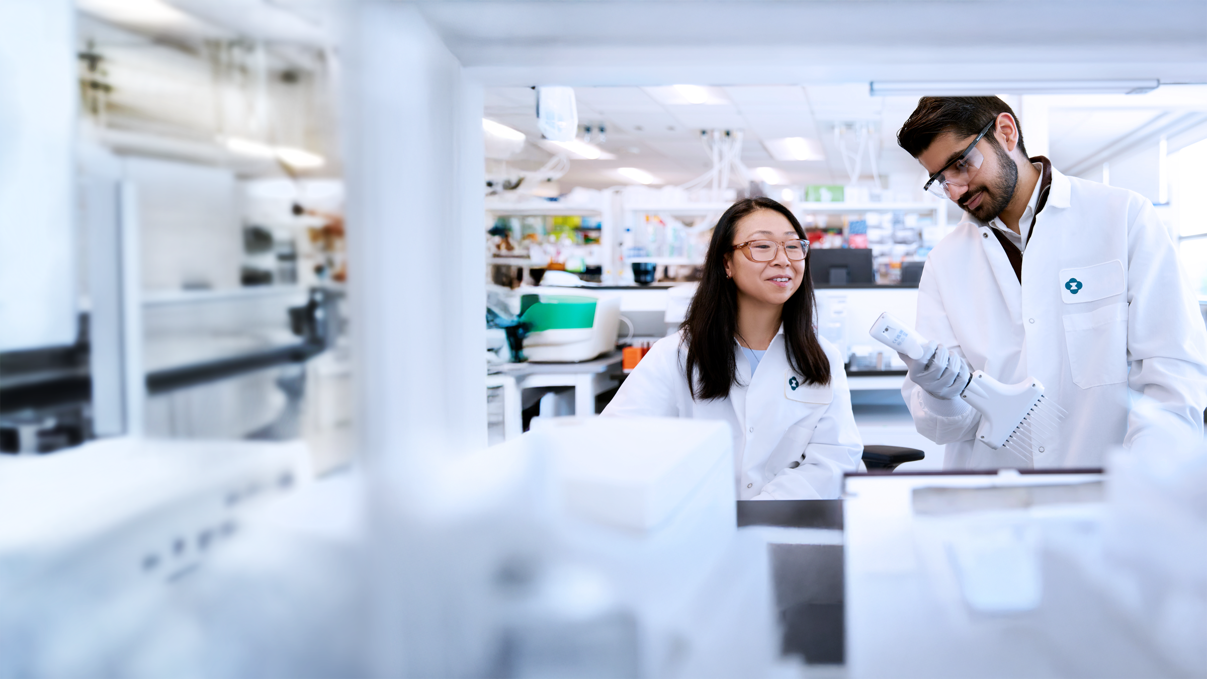 two scientists wearing lab coats working in a lab