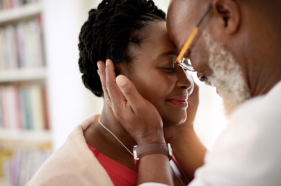 man gently holding face of woman and both are smiling
